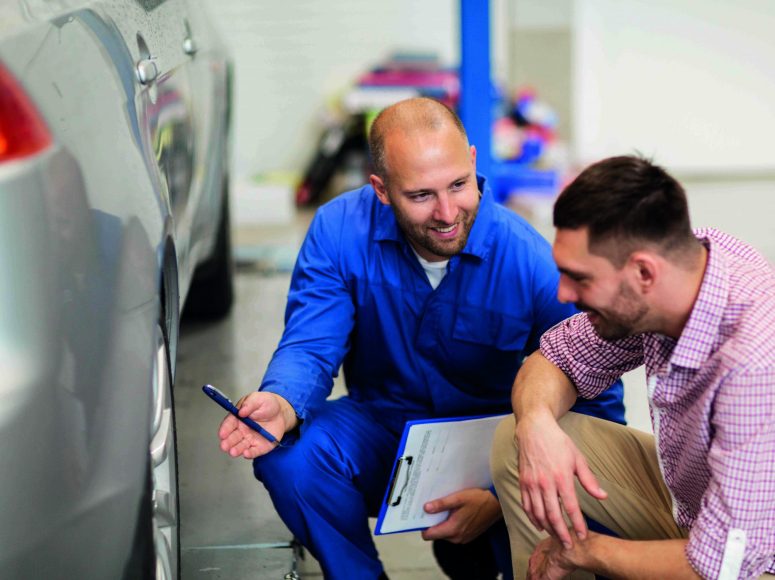 Mechaniker und Kunden besprechen Herstellergarantie beibehalten bei TOP Markenspezialist Autohaus Harmsen. Spezialist für Renault, Dacia